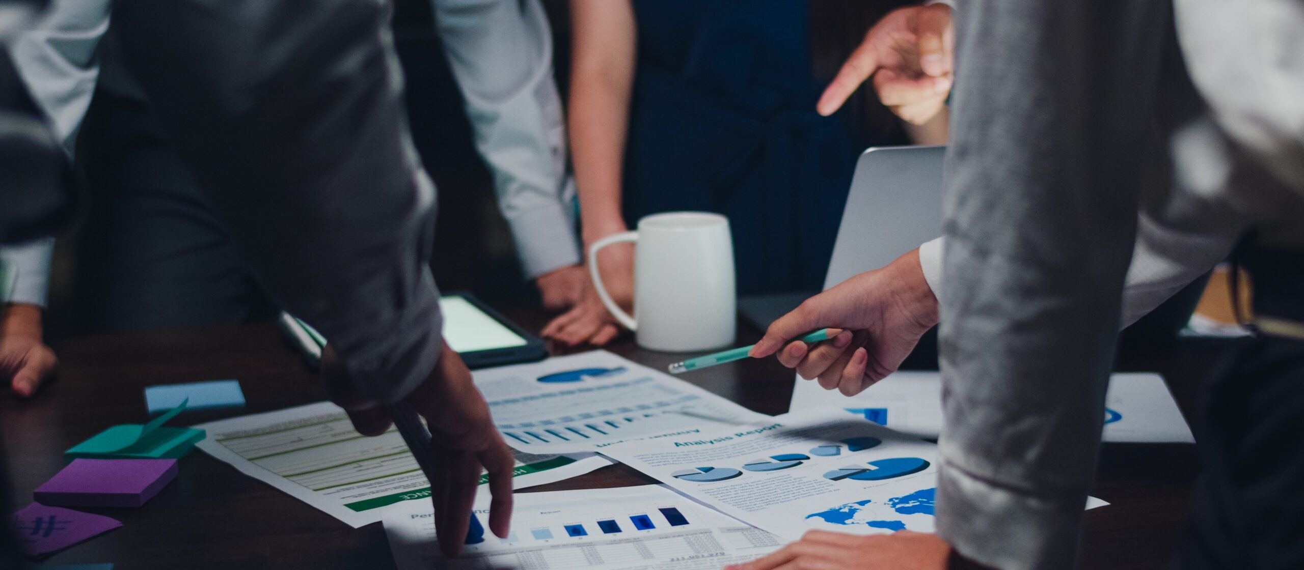 Millennial Asia businessmen and businesswomen meeting brainstorming ideas about new paperwork project colleagues working together planning success strategy enjoy teamwork in small modern night office.